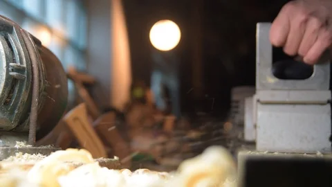 Carpenter with a electric planer at work in the workshop. Slow-motion close-up Video stock 128386762