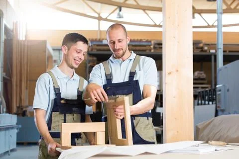 Carpenter examining work of a trainee Stock Photos
