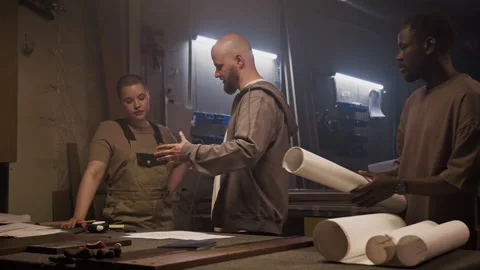 Carpenter Explaining Woodworking Plan to Female Apprentice Video stock 292780651