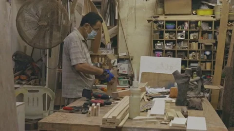 Carpenter with face mask on working alone at his studio during COVID-19 Stock Footage 137029615