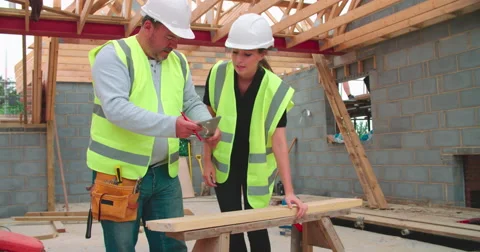 Carpenter With Female Apprentice Measuring And Cutting Wood Video stock 56221714