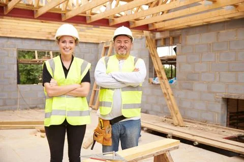 Carpenter With Female Apprentice Working On Building Site Stock Photos