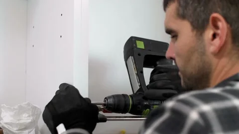 The carpenter finalizing the assembly of the kitchen shelf 動画素材 147314757