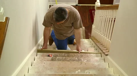 Carpenter fitting in stair riser and measuring for the step Stock Footage 50868129