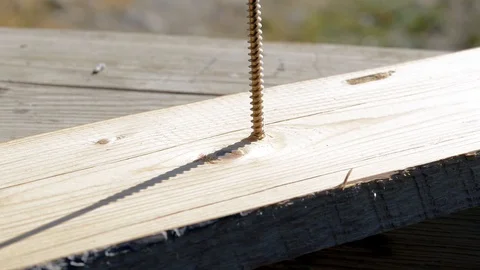 Carpenter fixing pine board with a long screw Stock Footage 96329471