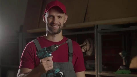 A carpenter focuses on his work as he holds a screwdriver, engaging directly 스톡 동영상 281673337