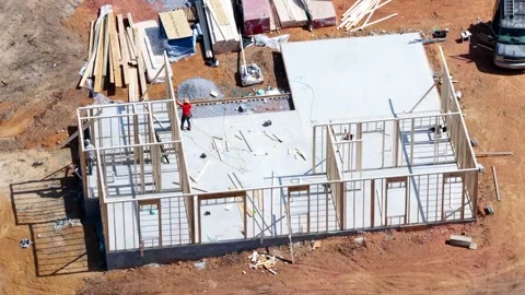 Carpenter framing walls on a new house subfloor Stock Footage 346174789