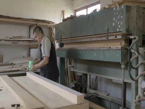 Carpenter get out glued planks from drying machine in workshop. 動画素材 80011520