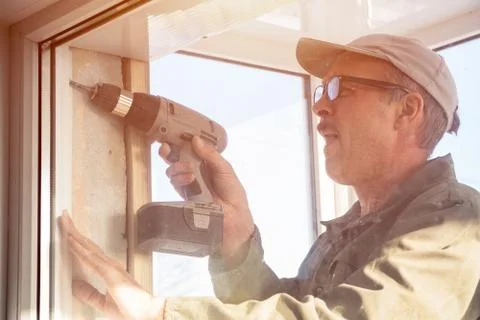 Carpenter in glasses with a drill Stock Photos