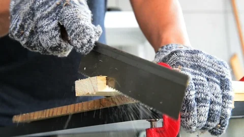 Carpenter in gloves using wood saw for sawing wood sheet. Stock Footage 124738246