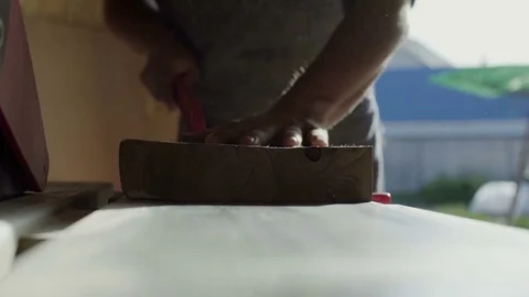 Carpenter grinding plank on machine. pushing wooden board right on camera Stock Footage 76084865