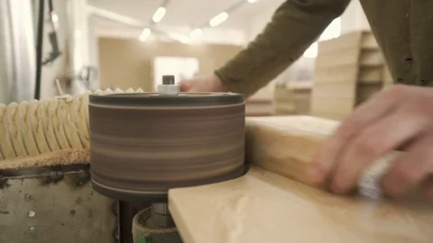 Carpenter grinds a board on a machine Stock Footage 128369702