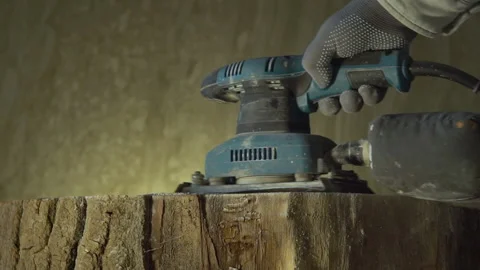 The carpenter grinds the surface of natural wood with a vibrating grinder Stock Footage 218366503
