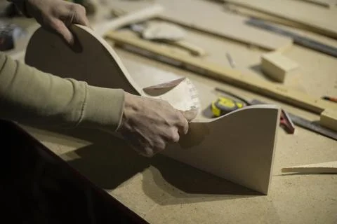Carpenter grinds wood. Process of creating furniture from wood. Board process Stock Photos