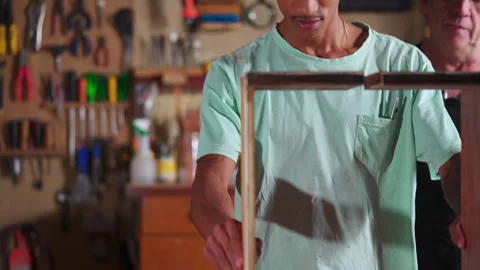 Carpenter Guiding Apprentice at Carpentry Workshop, Teaching Woodwork Using.. Stock Footage 247307205