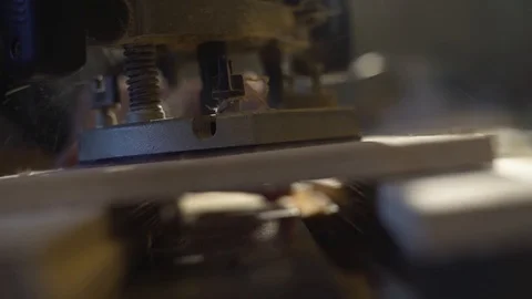 The carpenter with a hand-held mill cuts out a circle from a wooden shield Stock Footage 107614693