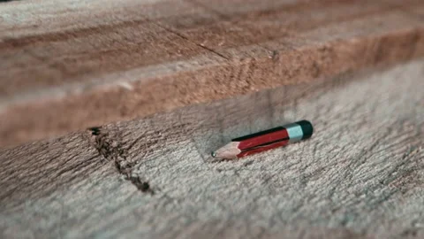 Carpenter hand taking a pencil to mark measurement on wooden plank Stock Footage 143610477