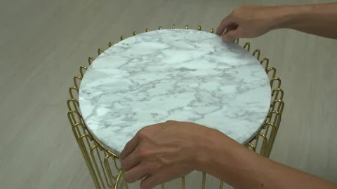 Carpenter hands re adjusting marble top from gold stand table luxury Stock Footage 251772532