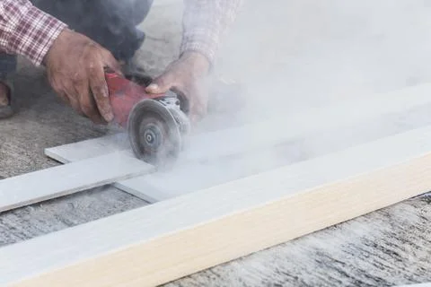 Carpenter hands using electric saw on wood at construction site Stock Photos