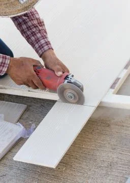 Carpenter hands using electric saw on wood at construction site Foto stock