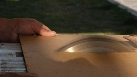 Carpenter hands using stationary circular saw to cut hardboard during furniture  Stock Footage 332875888