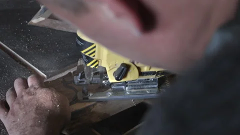 A carpenter in his workshop saws with an electric jigsaw, makes wooden parts Stock Footage 206035004