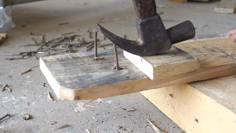 Carpenter is holding a hammer with pulling the nail out of the wood. 스톡 동영상 107259399