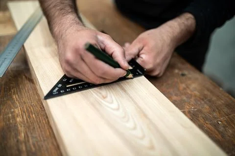 Carpenter holding a set square on the work bench Stock Photos
