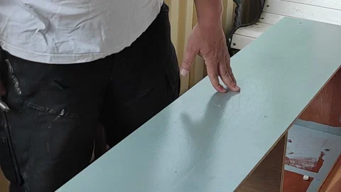 Carpenter on home balcony outlines line with pencil,meter,selects jigsaw,battery Stock Footage 156573752