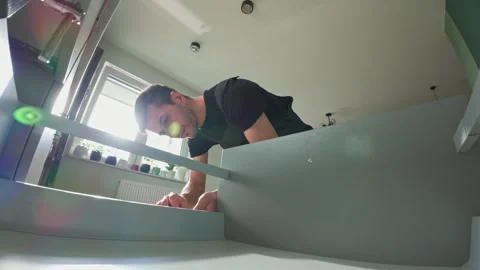 Carpenter installing and adjusting drawer front in modern kitchen cabinet Stock Footage 306578554