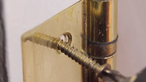Carpenter installing golden hinge on white door with electric screwdriver 库存影片 304118086