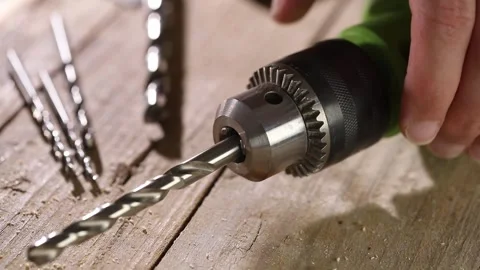 Carpenter installs a drill bit into an electric drill. close-up shot. Stock Footage 247498567