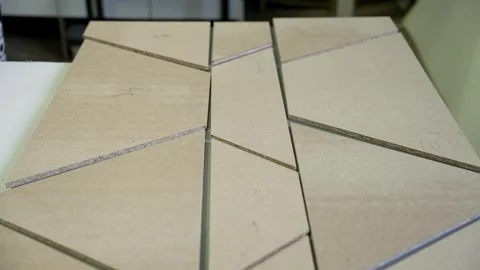 Carpenter joining wooden triangles on table Stock Footage 309011148