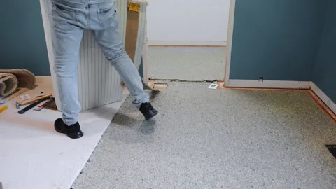 Carpenter lifting up old carpet roll and taking it away during home repair Stock-Footage 318677035