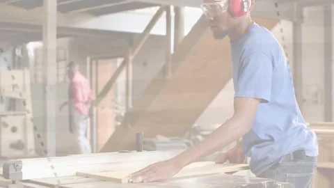 Carpenter lifting panel, aligning with fence, guiding board through table saw Stock Footage 334316475