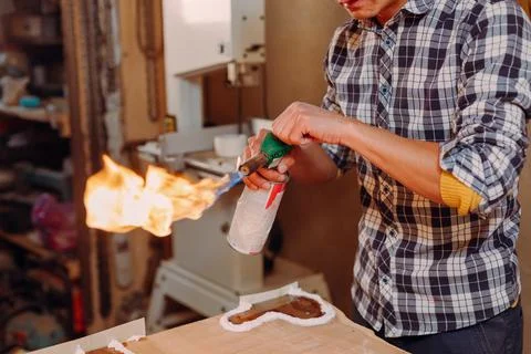 Carpenter lighting a blowtorch in a workshop Stock Photos