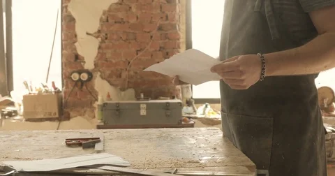 Carpenter looking on a drawing, close-up, in a carpentry workshop Stock-Footage 74715149