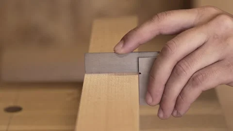 Carpenter looking at the level after planing the wood Stock Footage 242335742