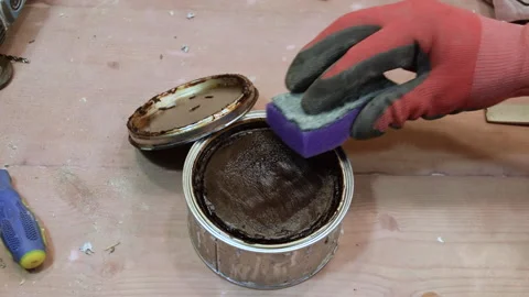 The carpenter lubricates the sponge with wax for applying it to the wood. Stock Footage 156178134