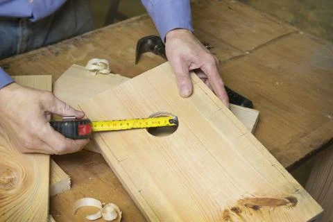 Carpenter makes a birdhouse in the workshop Stock Photos