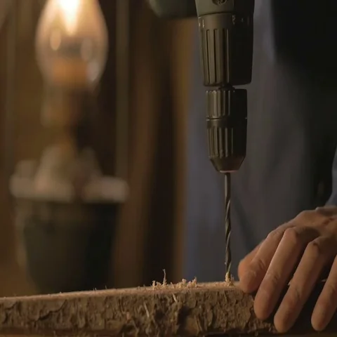 The carpenter makes a hole in the Board drill. master works in the Studio tool Stock-Footage 69518245
