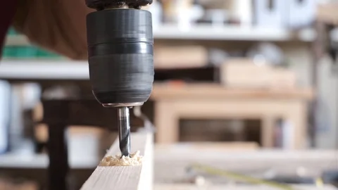 Carpenter making a drill with a spinning top on a wooden board Stock Footage 123121608