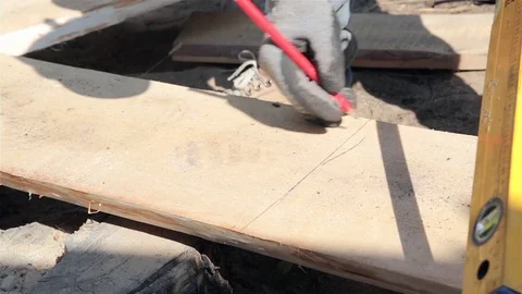 Carpenter making measurements and sawing a plank. Video stock 77908097