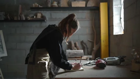 Carpenter making sketches in notepad in workshop Stock Footage 167421542
