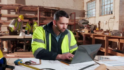 Carpenter, man and typing in factory with laptop, review woodwork design and Stock Footage 338045462