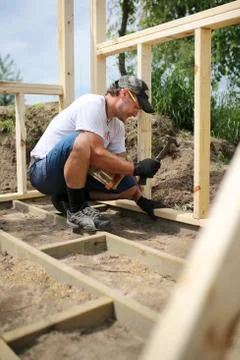 Carpenter Man Building Frame and Floor for Backyard Garden Shed Stock Photos