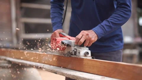 Carpenter man using electric planer to smooth out the wood Stock Footage 268777077