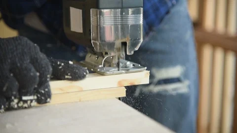 Carpenter man worker using electric hand saw cutting wood plank Stock Footage 125356475