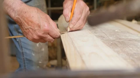Carpenter marking bevel edge on plank Stockbeeldmateriaal 345687927