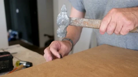 Carpenter marking laminate details with hammer and nails Stock Footage 135712005